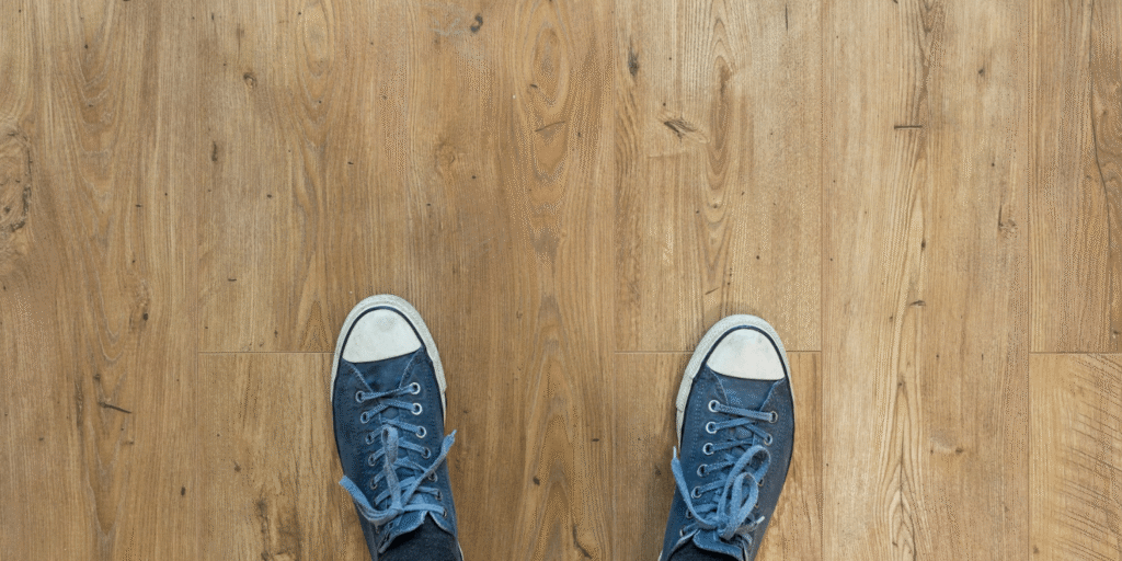 Barbers Flooring | An image showing a person with blue shores stood on a hard wooden floor