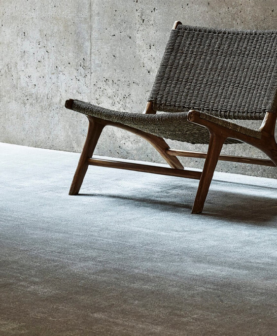 Barbers Flooring | An image showing a hand woven chair sitting on a grey carpet